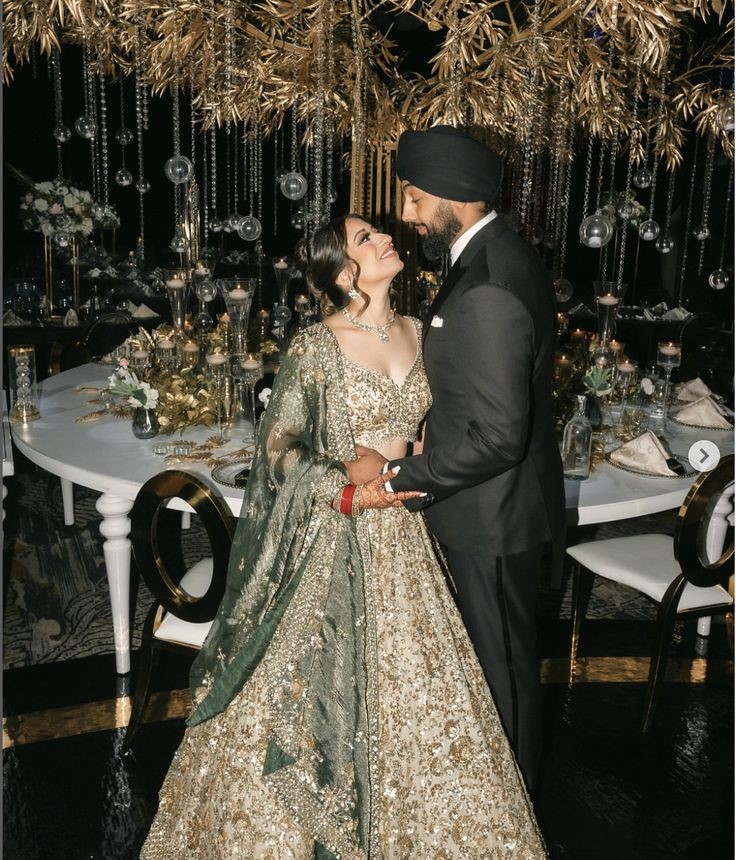 Bride and groom wearing emerald green and gold coordinated royal wedding outfits for luxury Indian wedding inspiration