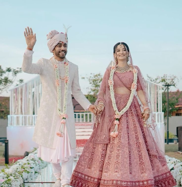 Bride and groom wearing pastel pink lehenga and beige sherwani for modern Indian wedding inspiration